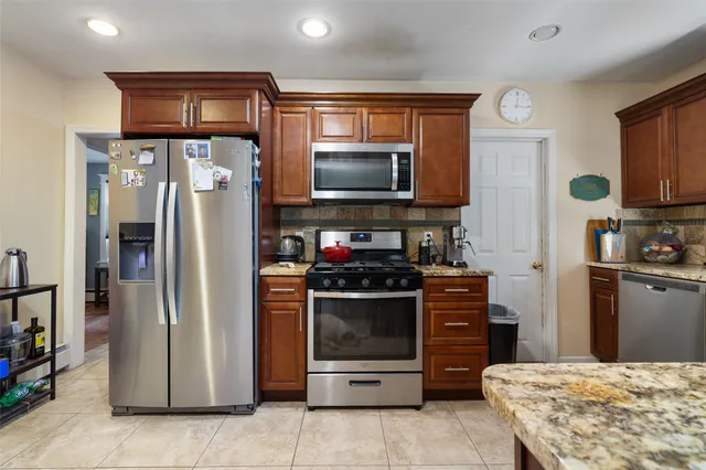 a kitchen with stainless steel appliances granite countertop a refrigerator and a stove top oven