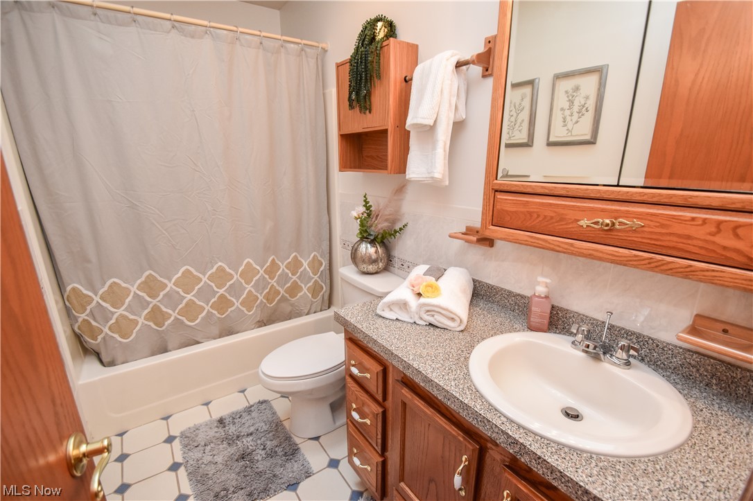 5050 Canfield Road Canfield, OH 44406 - Photo 27 of 47 Full bathroom featuring tile flooring, vanity, toilet, and shower / bath combo with shower curtain
