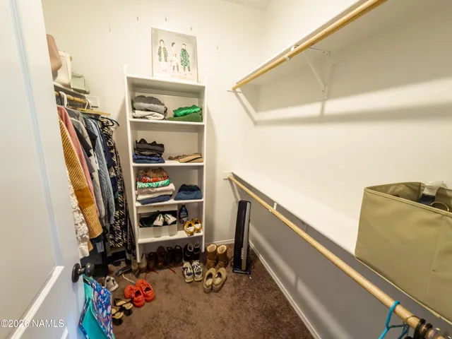 a view of walk in closet with clothes and shoes