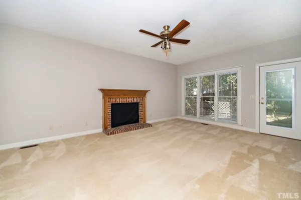a view of empty room with windows and fireplace
