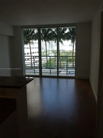 a view of a room with wooden floor and a window