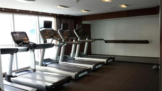 a view of gym equipment with two windows
