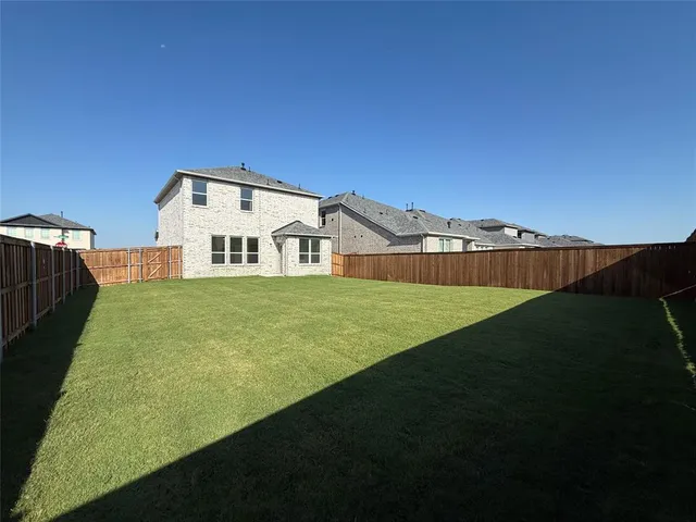 a view of a big house with a big yard and large trees