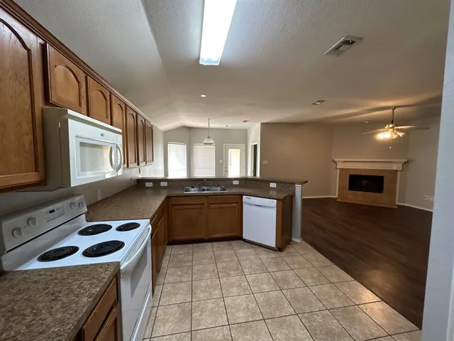a view of empty room with wooden floor and fireplace