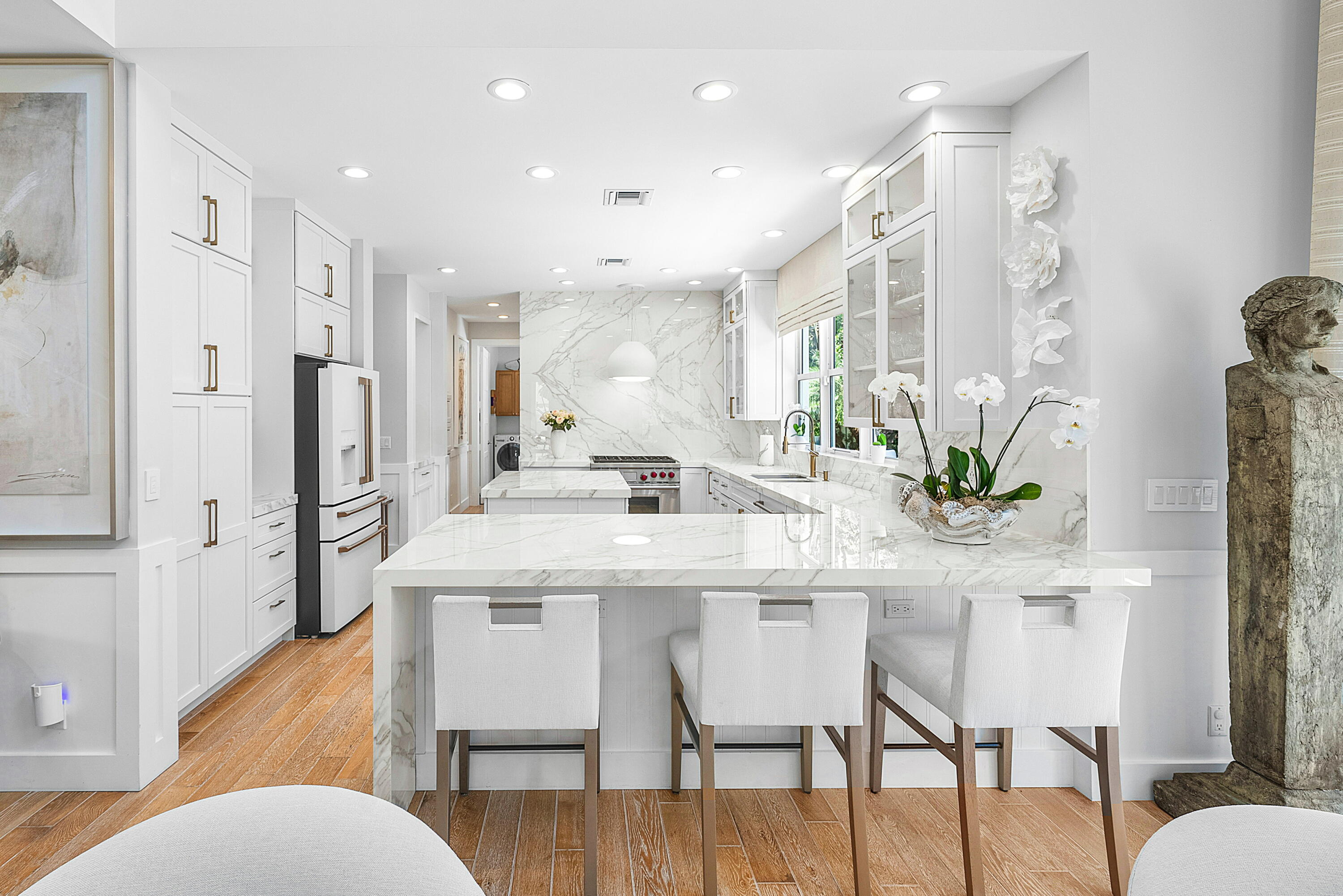 540 Northeast Spanish Trail Boca Raton, FL 33432 - Photo 13 of 47 a kitchen with stainless steel appliances kitchen island granite countertop a dining table chairs and a refrigerator
