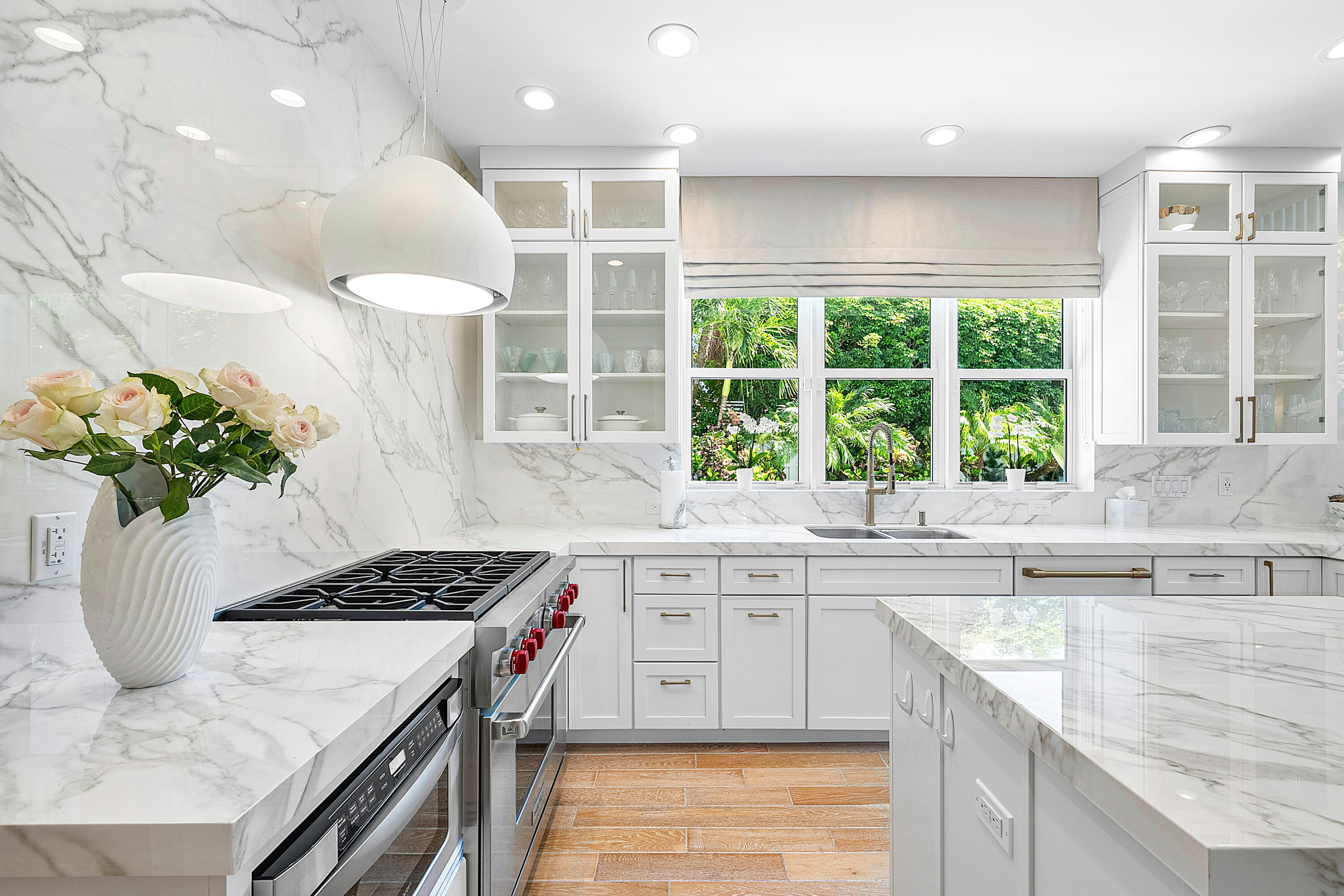 540 Northeast Spanish Trail Boca Raton, FL 33432 - Photo 17 of 47 a kitchen with stainless steel appliances granite countertop a sink a stove a kitchen island and windows