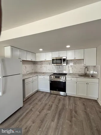 a kitchen with stainless steel appliances granite countertop a refrigerator and stove top oven