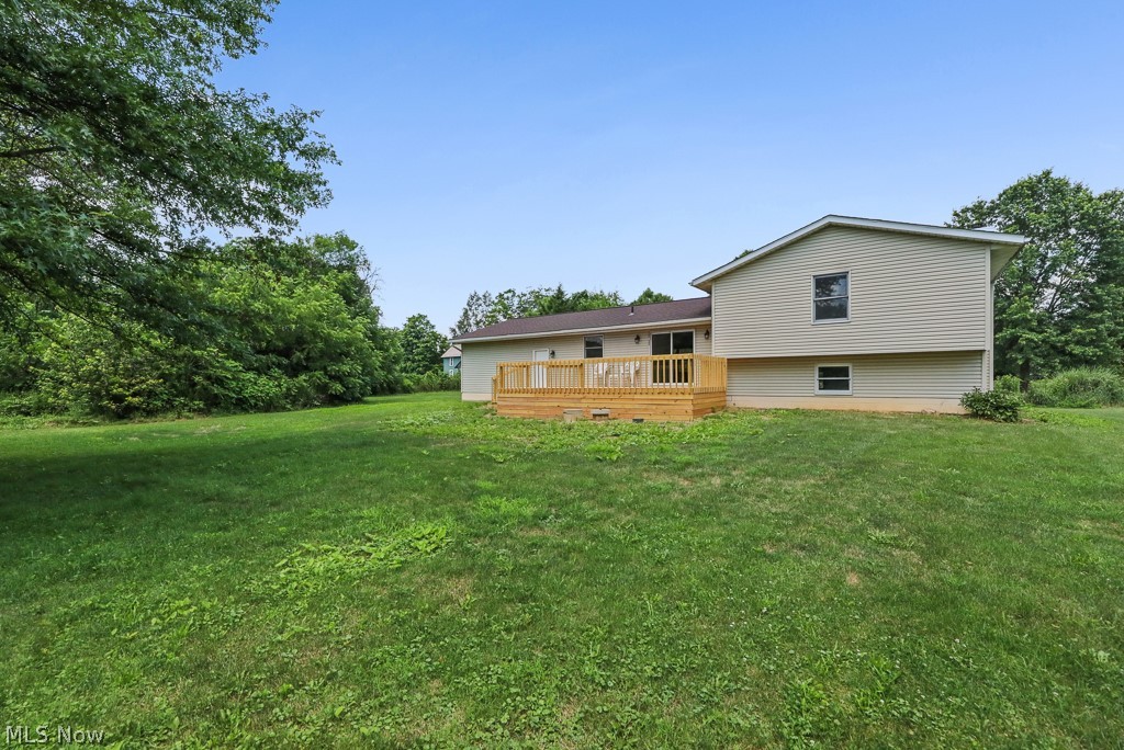 2642 Blake Road Wadsworth, OH 44281 - Photo 40 of 46 Expansive rear yard featuring a large wooden deck, beige siding, and surrounding mature foliage