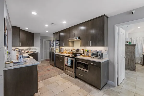 a kitchen with stainless steel appliances kitchen island granite countertop a stove and a sink