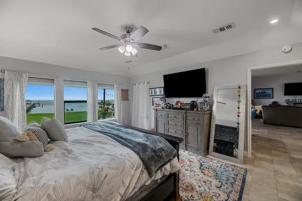 a large bedroom with a bed and flat tv
