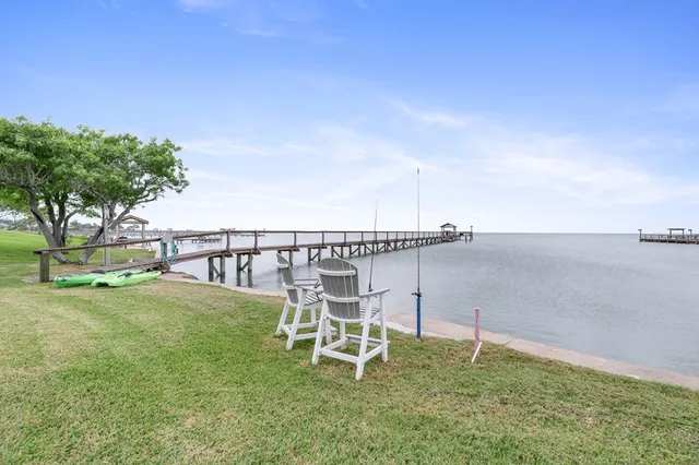 a lawn chair sitting in the grass near a yard