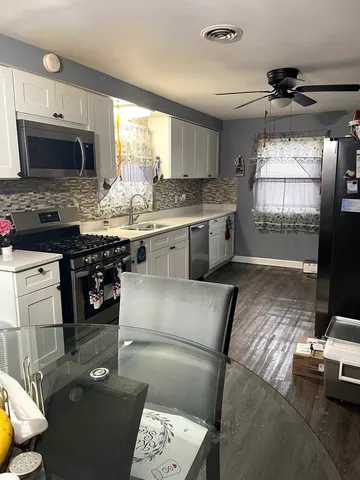 a kitchen with stainless steel appliances granite countertop a stove sink and cabinets