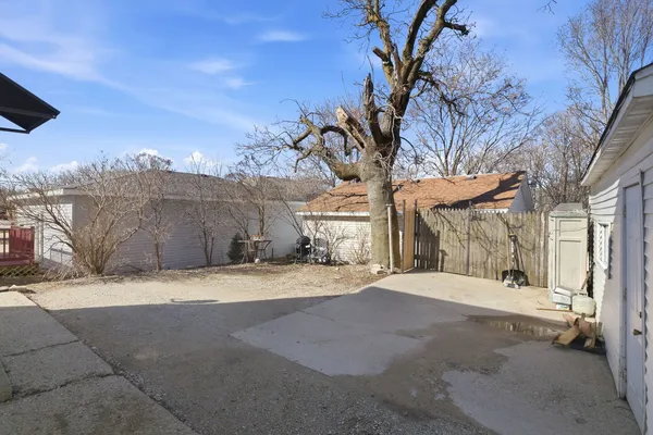 a big house with large trees and a wooden fence