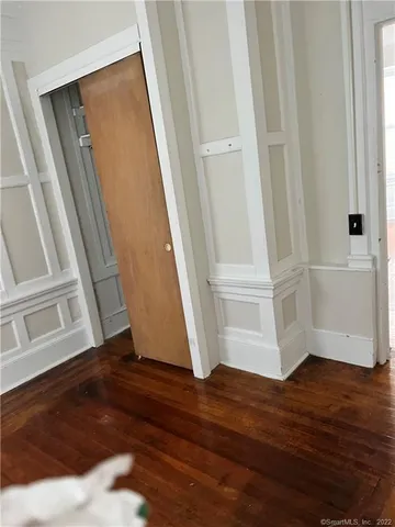 an empty room with wooden floor and entrance