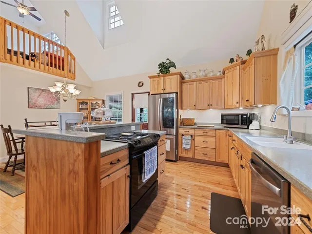 a kitchen with stainless steel appliances granite countertop a stove a sink dishwasher and a refrigerator