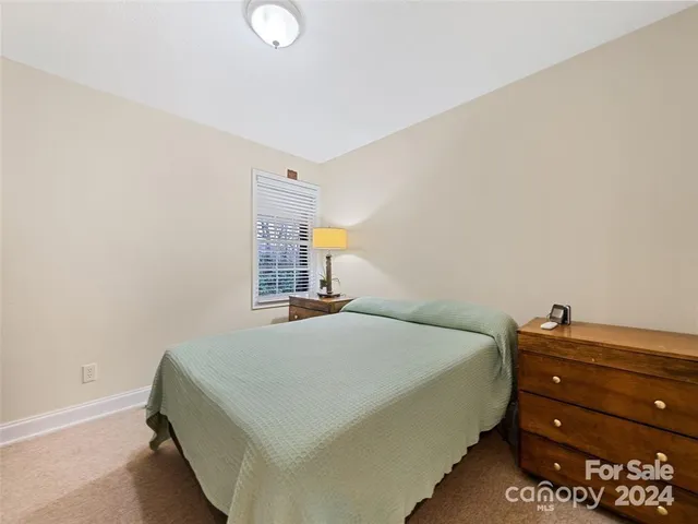 a bedroom with a bed and a night stand