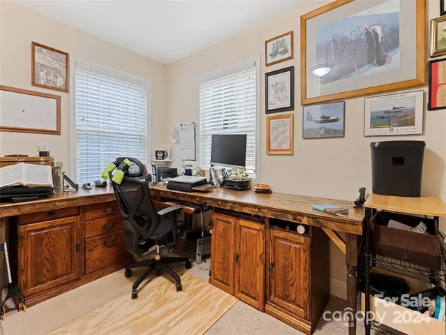 a view of a workspace with furniture and a window