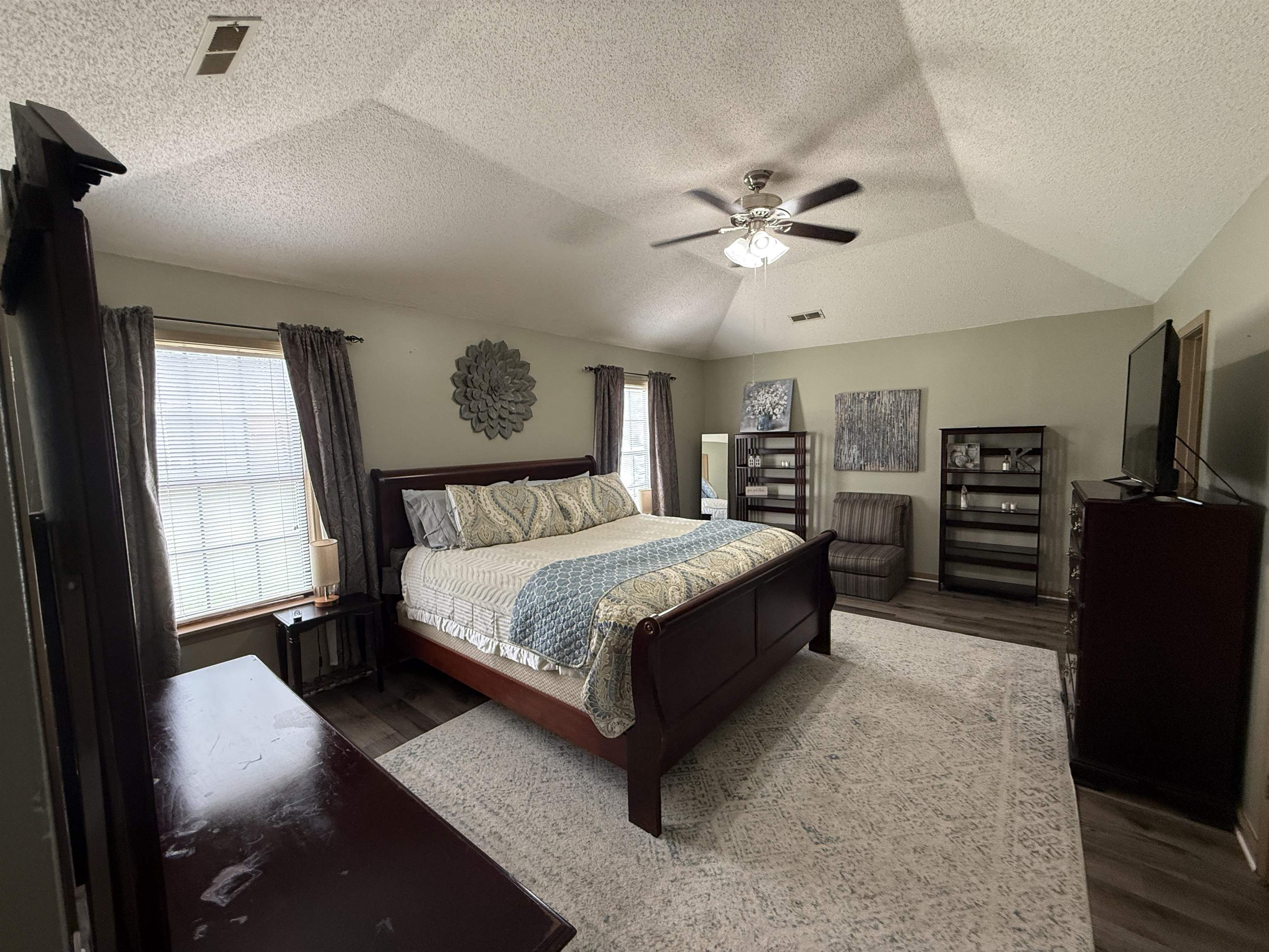 185 Mignon Road Atoka, TN 38004 - Photo 22 of 34 Spacious room featuring a vaulted ceiling with a ceiling fan, dual windows with blinds, and wood-finish flooring