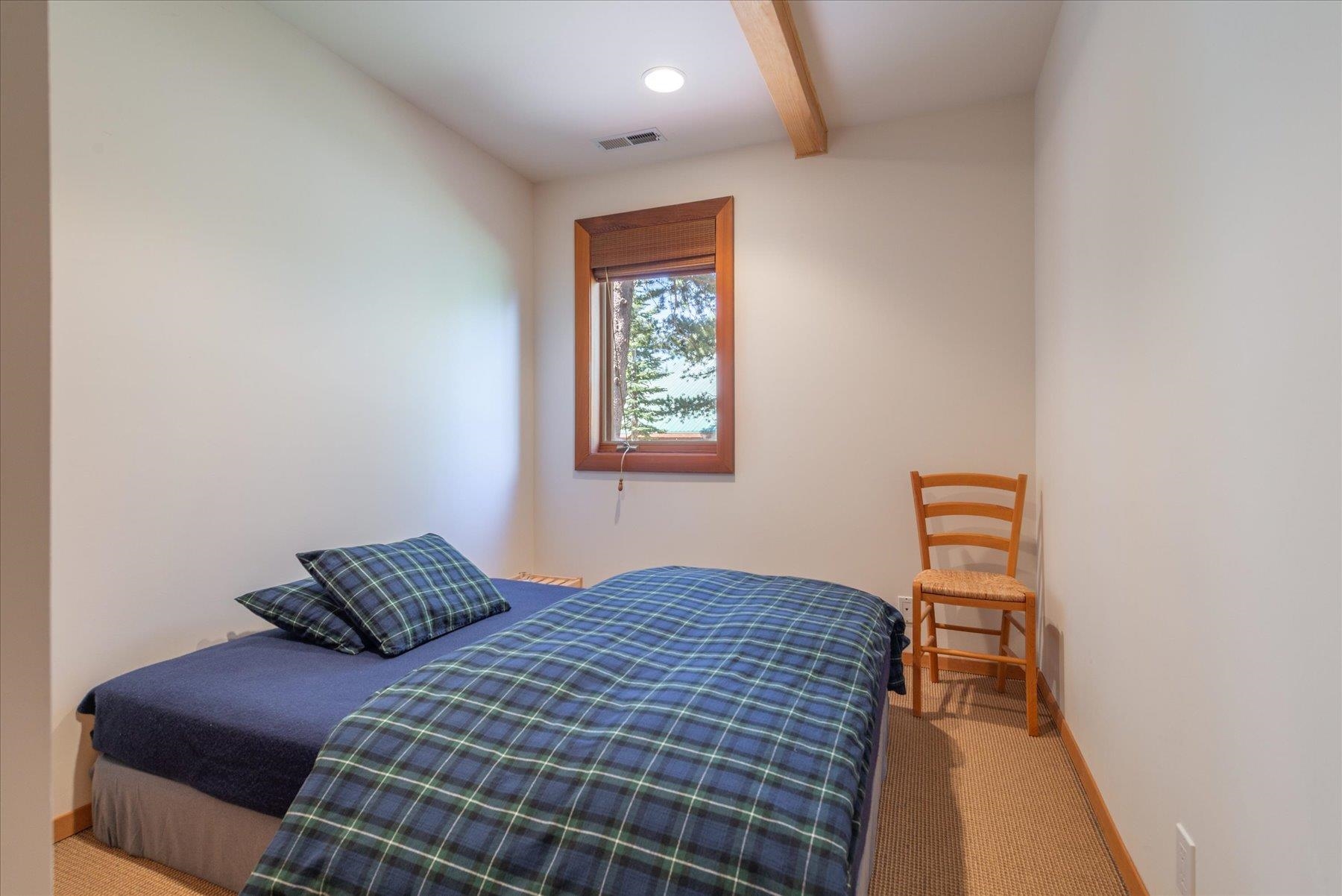 15009 Ski Slope Way Truckee, CA 96161 - Photo 14 of 28 a bedroom with a bed and a lamp with the wall