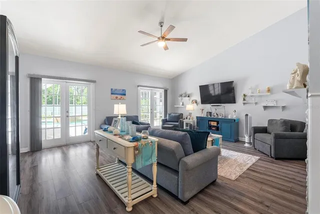 a kitchen with stainless steel appliances granite countertop a refrigerator a sink dishwasher stove and white cabinets with wooden floor