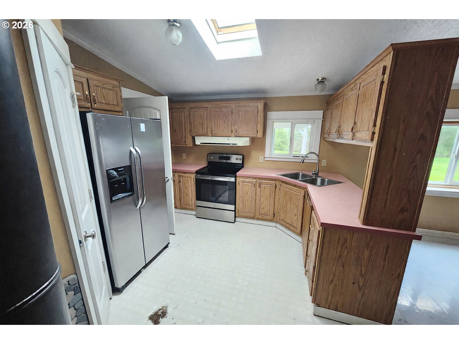 85106 Territorial Highway Eugene, OR 97402 - Photo 7 of 48 a open kitchen with refrigerator a sink dishwasher and wooden cabinets