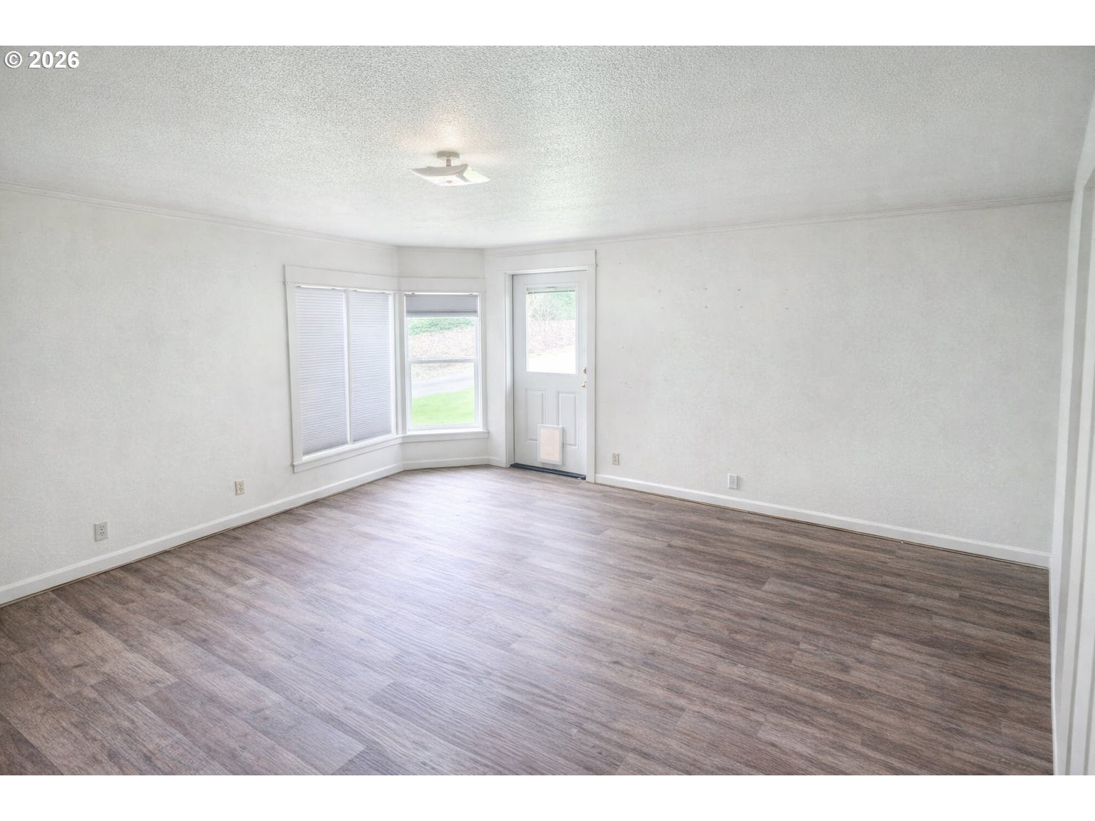 85106 Territorial Highway Eugene, OR 97402 - Photo 8 of 48 a view of an empty room with wooden floor and a window