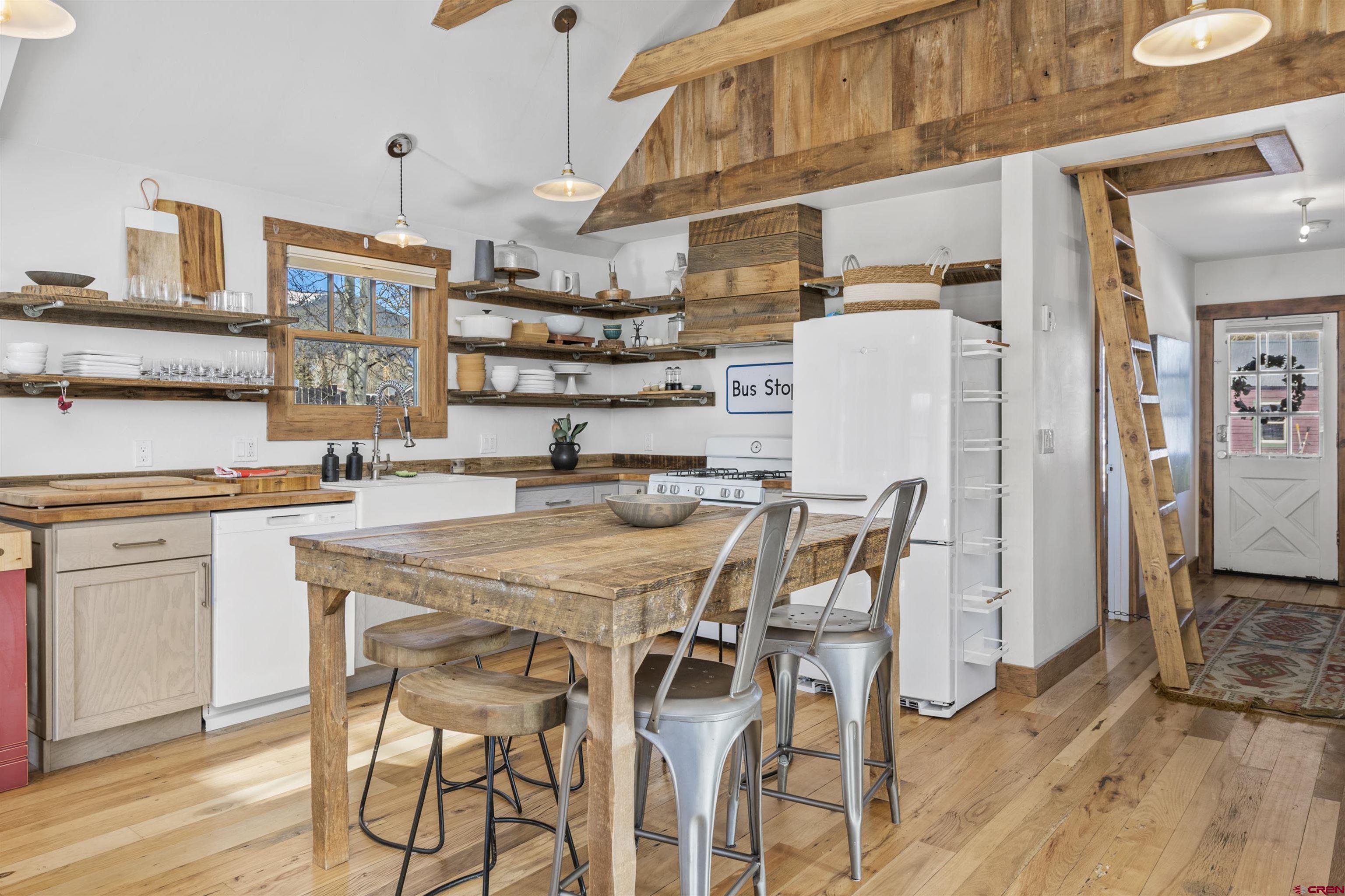 640 Elk Avenue Crested Butte, CO 81224 - Photo 31 of 45 a kitchen with stainless steel appliances kitchen island granite countertop a table chairs and a refrigerator
