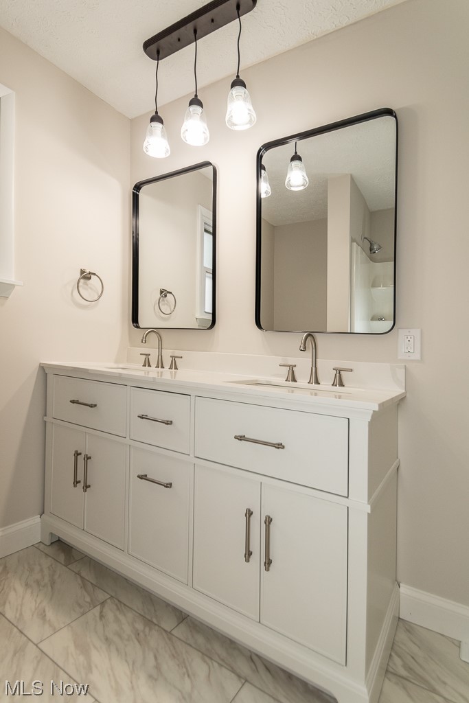 9490 Hoose Road Mentor, OH 44060 - Photo 19 of 27 Bathroom featuring dual bowl vanity, tile flooring, and a textured ceiling