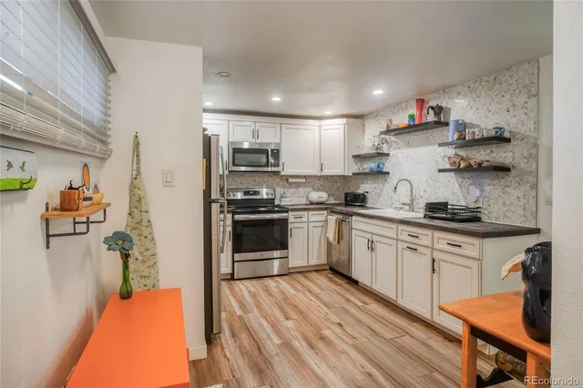 a kitchen with stainless steel appliances granite countertop a refrigerator sink and stove