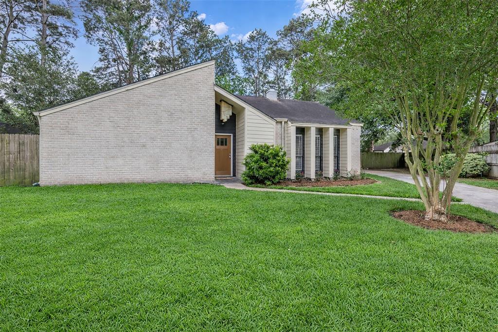 25703 Old Carriage Lane Spring, TX 77373 - Photo 1 of 25 The property features a well-maintained lawn, a paved driveway, and an exterior of light-colored brick and siding