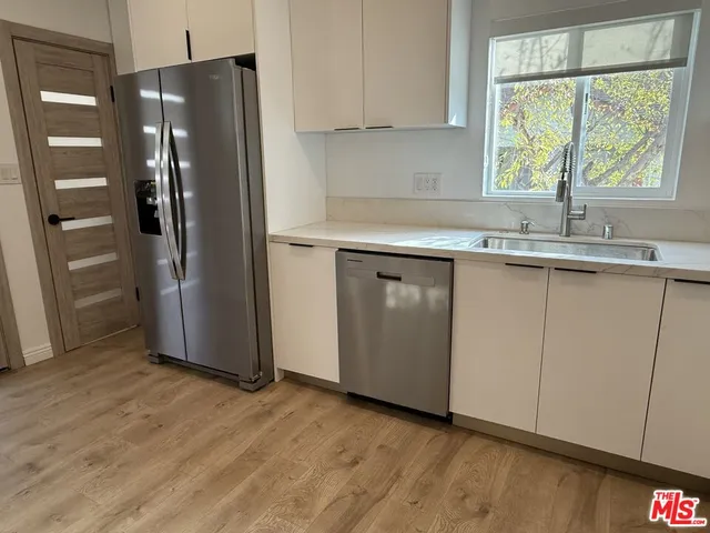 a kitchen with stainless steel appliances granite countertop a refrigerator and a sink