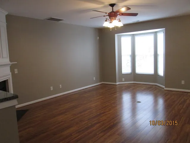 a view of room with window ceiling fan and hardwood floor