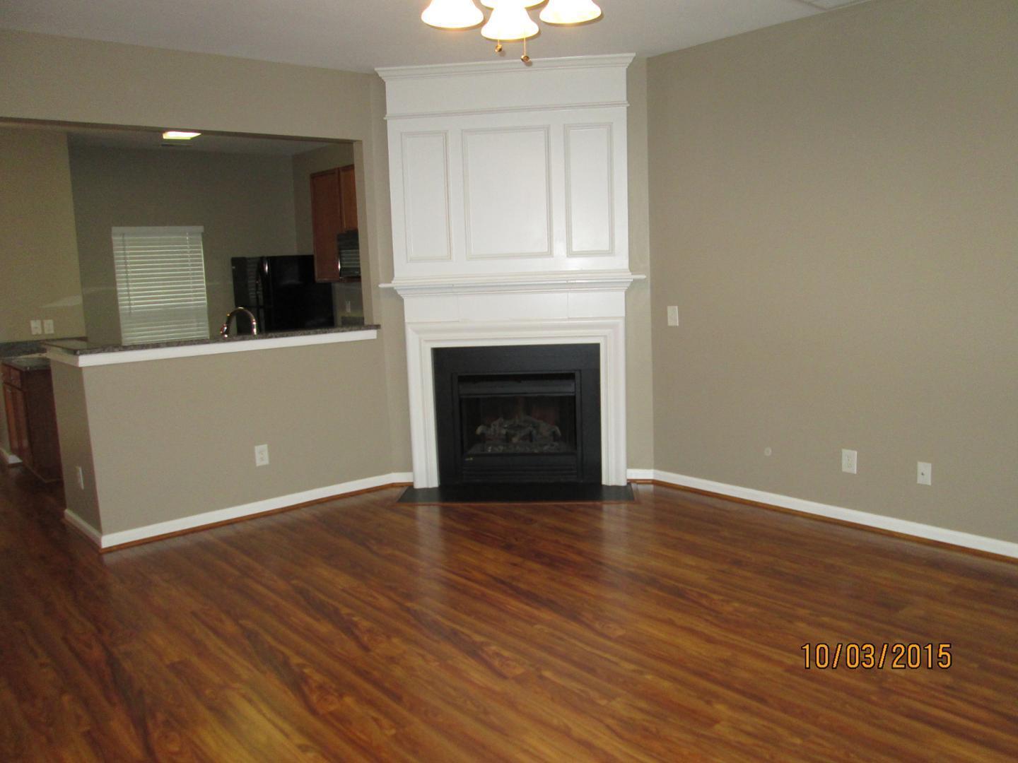 8521 Silhouette Place Raleigh, NC 27613 - Photo 4 of 20 an empty room with wooden floor fireplace and windows