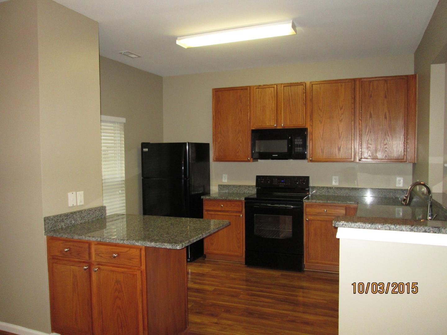 8521 Silhouette Place Raleigh, NC 27613 - Photo 5 of 20 a kitchen with granite countertop a stove top oven a sink and dishwasher a refrigerator with wooden floor
