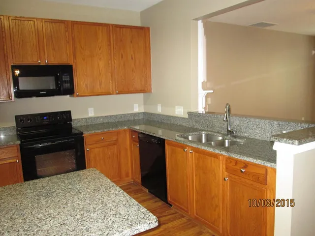 a kitchen with granite countertop stainless steel appliances a stove sink and microwave