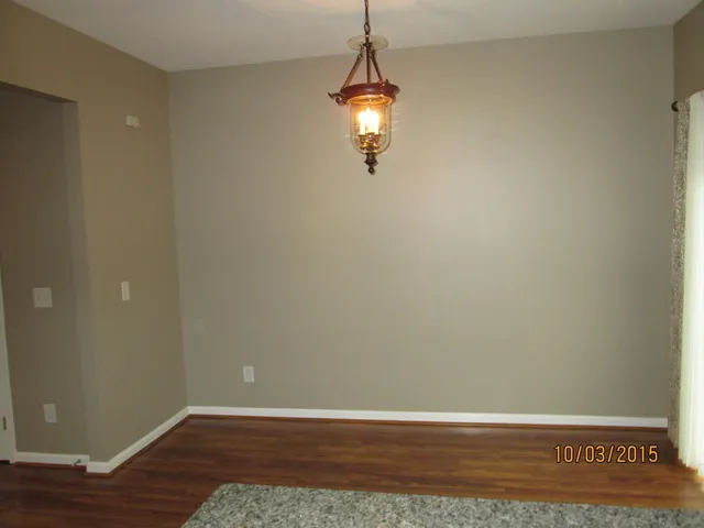 a view of a room with wooden floor and white walls