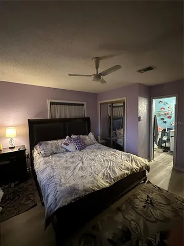 a bedroom with a large bed and a chandelier