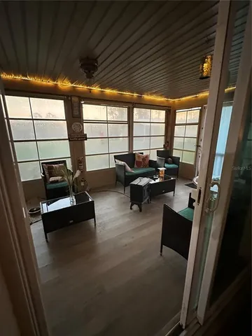 a living room with furniture floor to ceiling window and a flat screen tv