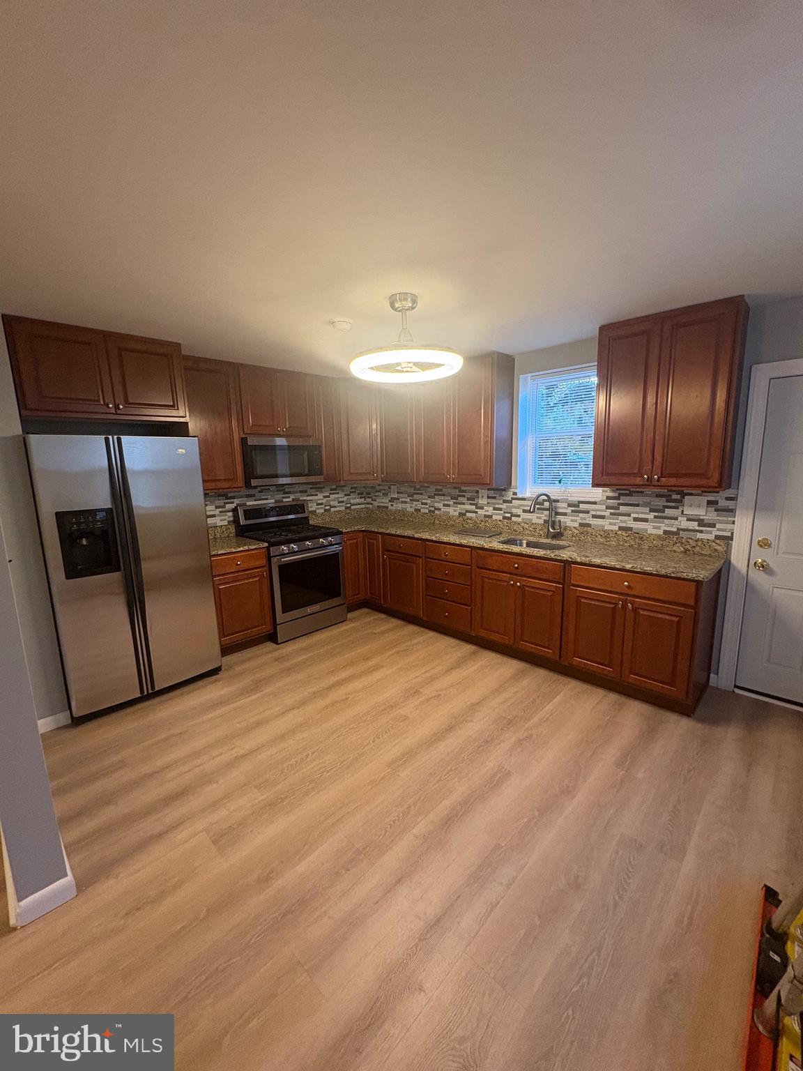4564 Bermuda Street Philadelphia, PA 19124 - Photo 8 of 17 a large kitchen with cabinets and stainless steel appliances
