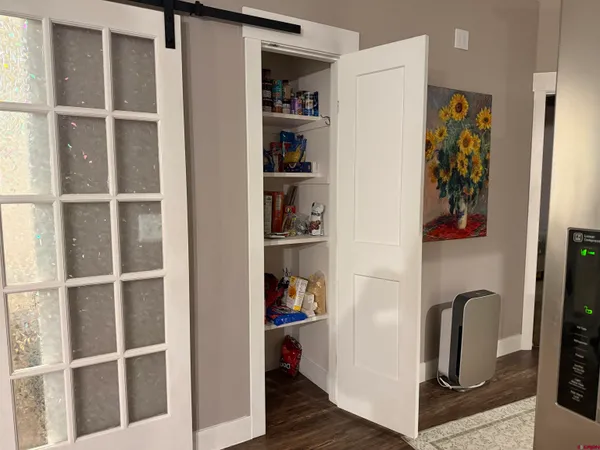 a picture of a bedroom with wooden floor and closet