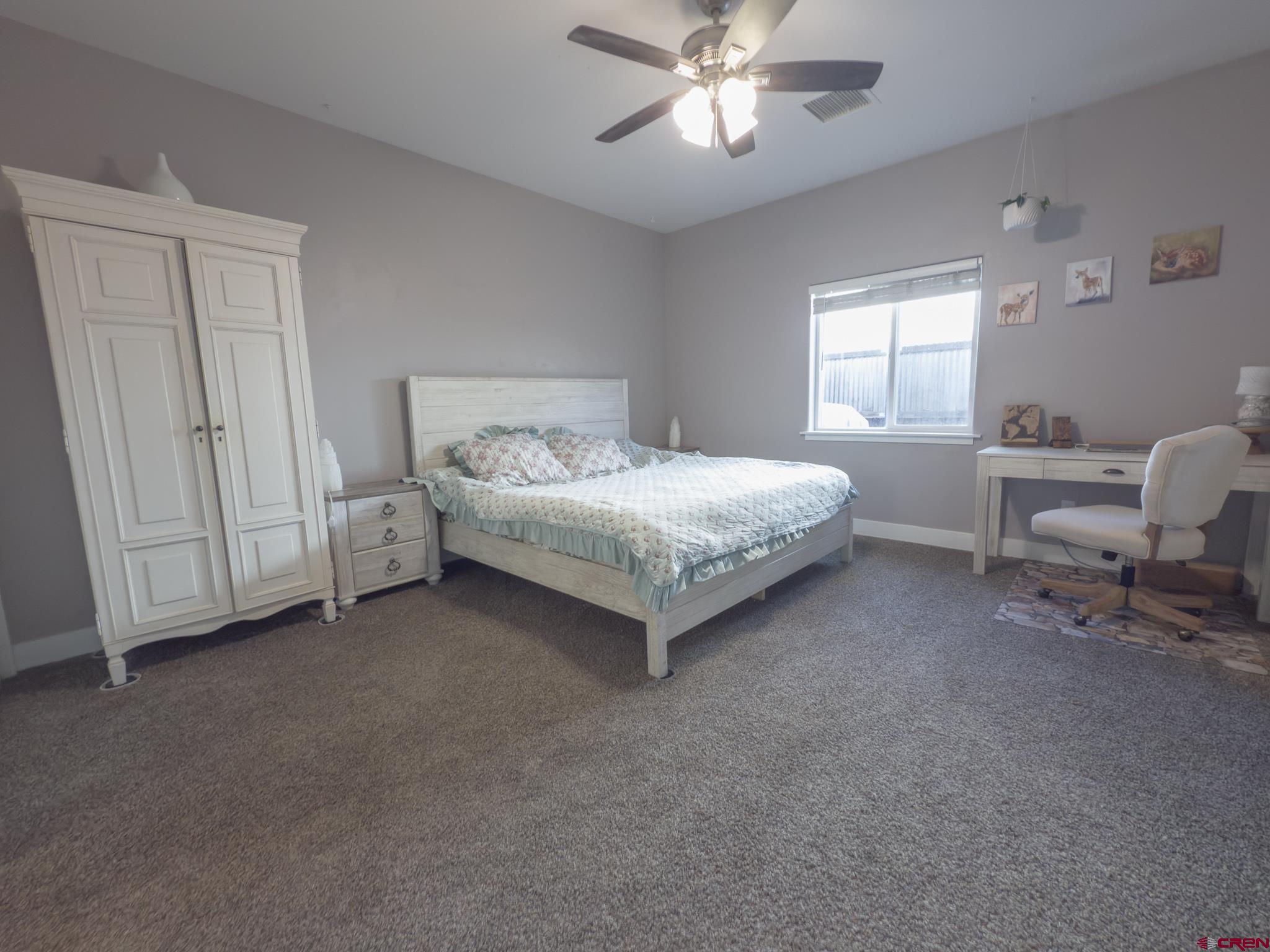 210 West 3rd Street, Unit 4 Cortez, CO 81321 - Photo 17 of 35 a spacious bedroom with a bed and a chandelier