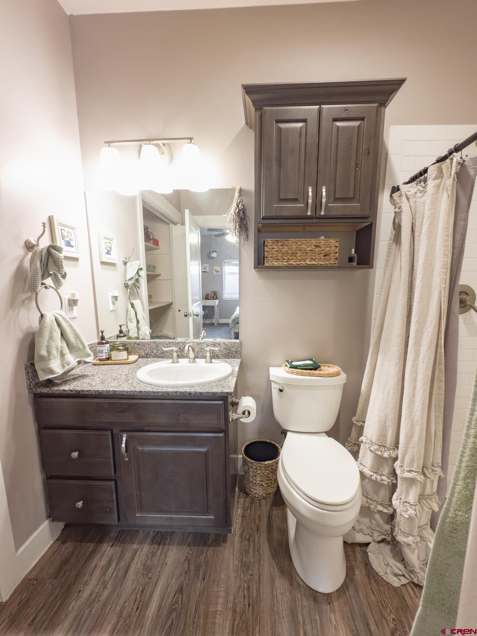 210 West 3rd Street, Unit 4 Cortez, CO 81321 - Photo 20 of 35 a bathroom with a granite countertop toilet sink and mirror