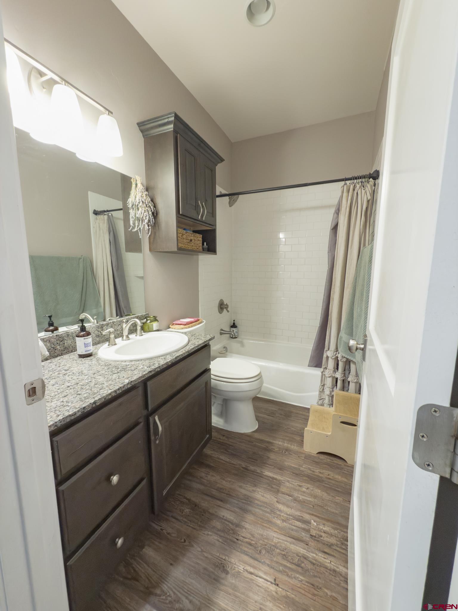 210 West 3rd Street, Unit 4 Cortez, CO 81321 - Photo 21 of 35 a bathroom with a granite countertop sink toilet and shower