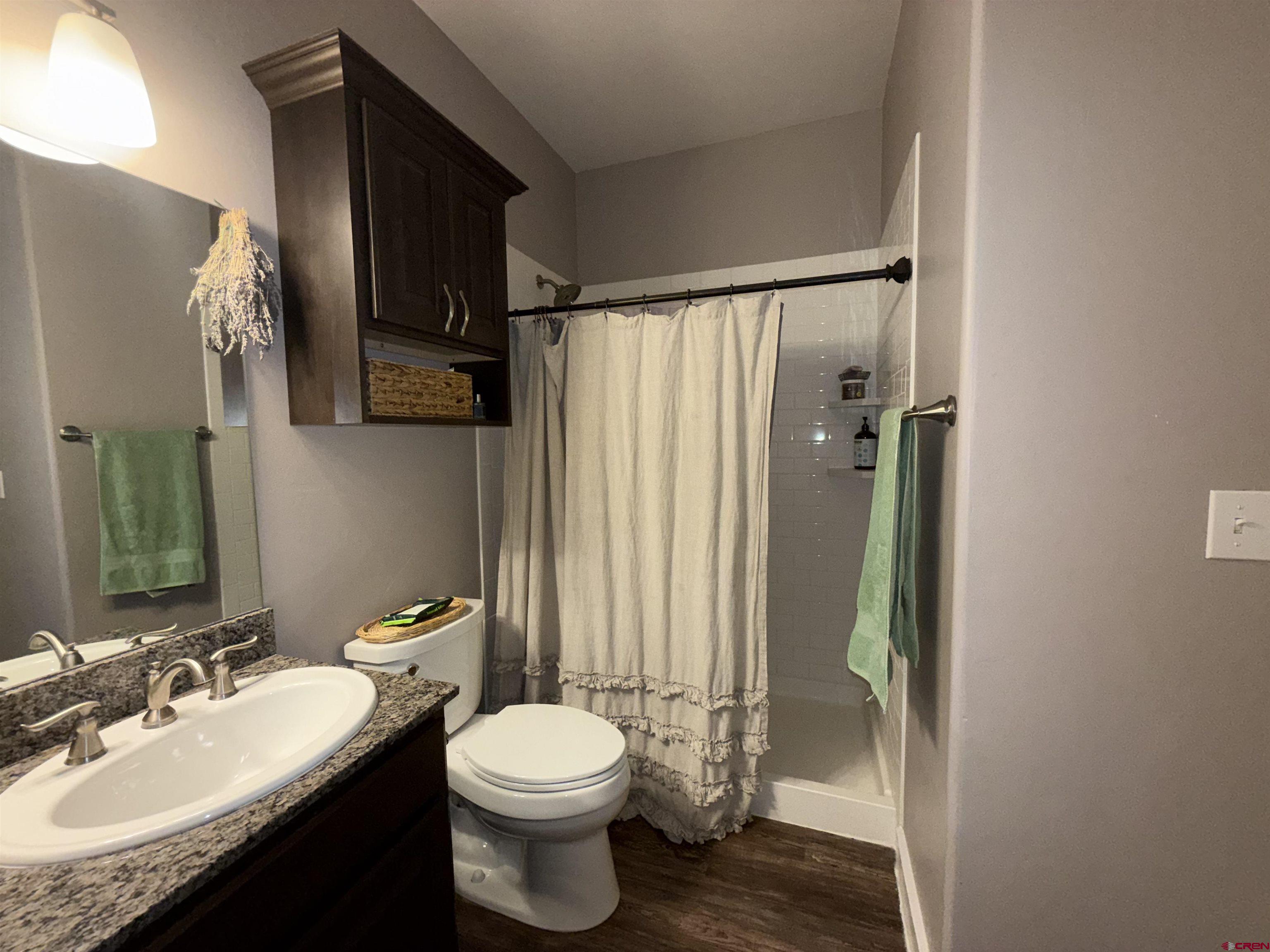 210 West 3rd Street, Unit 4 Cortez, CO 81321 - Photo 22 of 35 a bathroom with a granite countertop sink toilet and shower