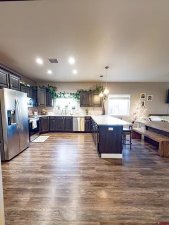 a room with stainless steel appliances kitchen island granite countertop a large counter top couches and cabinets