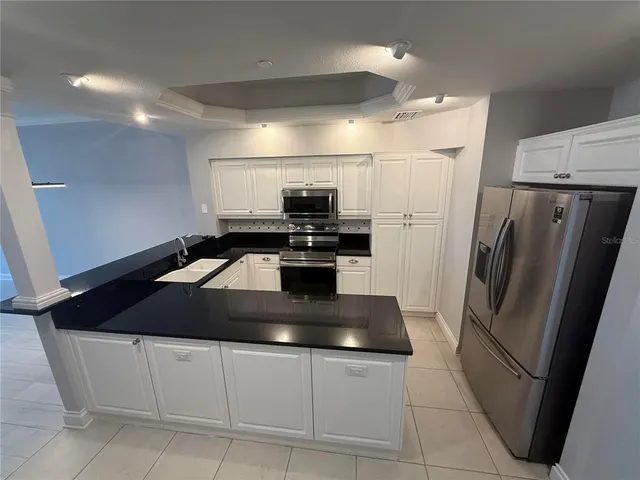 a kitchen with kitchen island a counter space a sink and stainless steel appliances