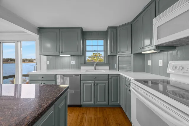 a kitchen with stainless steel appliances granite countertop a sink stove and cabinets