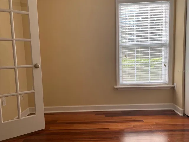 a view of a small space with wooden floor and a window