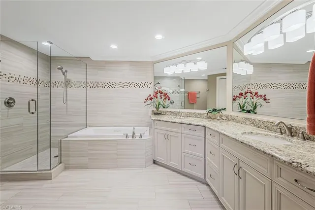 a spacious bathroom with a granite countertop sink mirror and bathtub