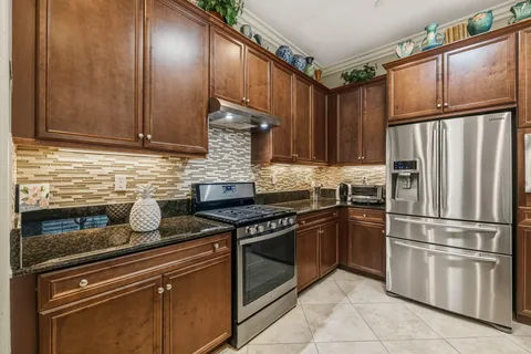 a kitchen with granite countertop stainless steel appliances and wooden cabinets